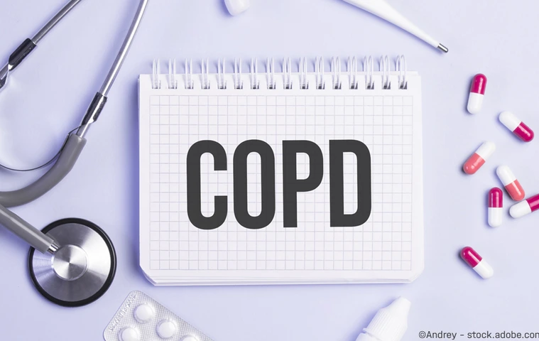 The word copd written on a white notepad on a blue background near a stethoscope, syringe, electronic thermometer and pills. Medical concept