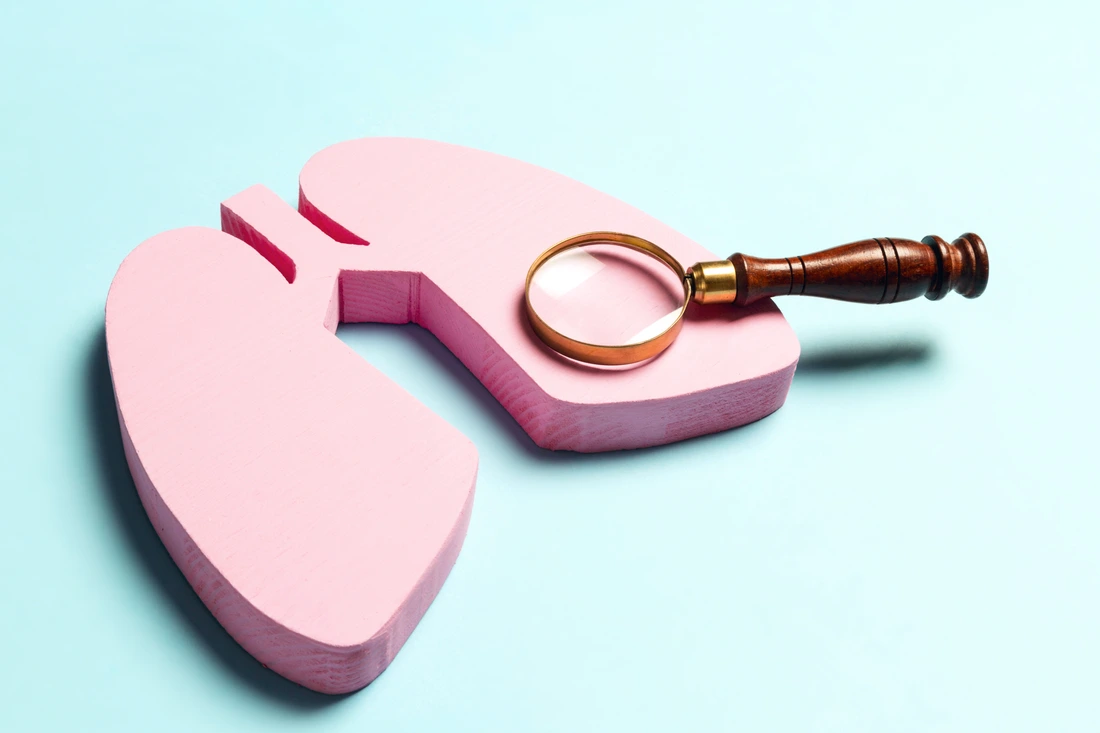 Prevention of pulmonary disease. Lung symbol with magnifier on a blue background.