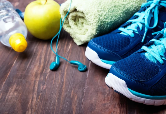 Sneakers, water, towel and earphones on the wooden background