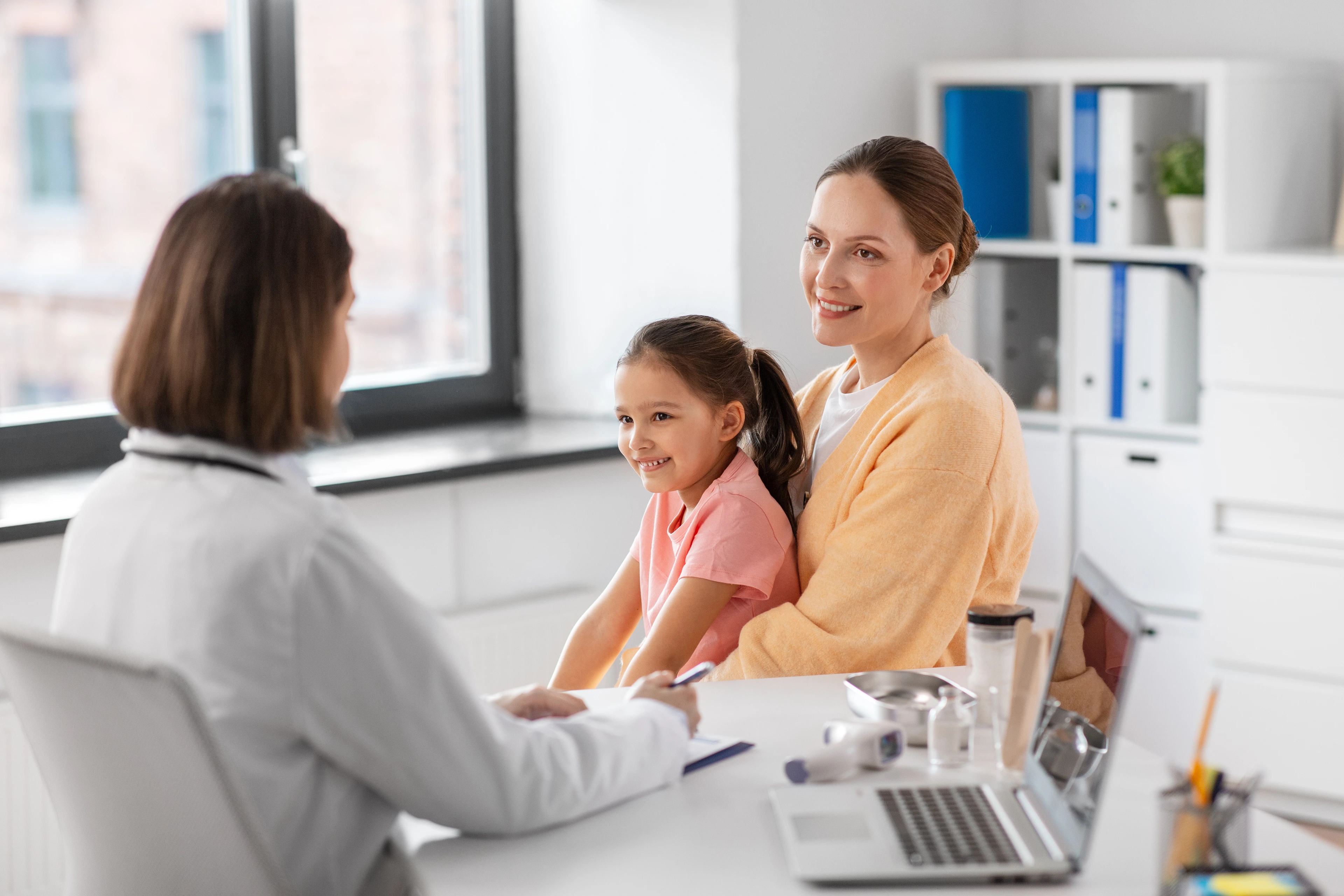 mother with little daughter and doctor at clinic
