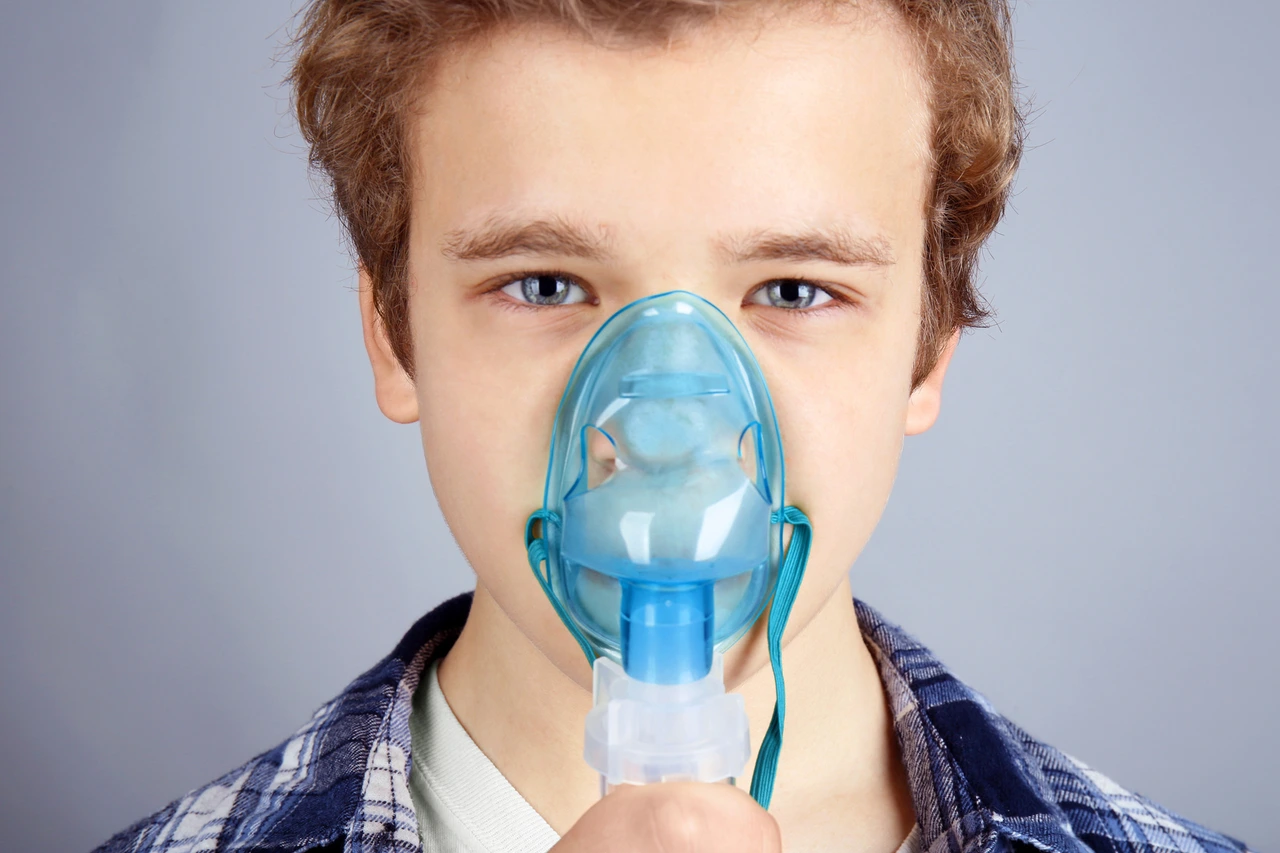 Young boy using nebulizer for asthma and respiratory diseases on light background