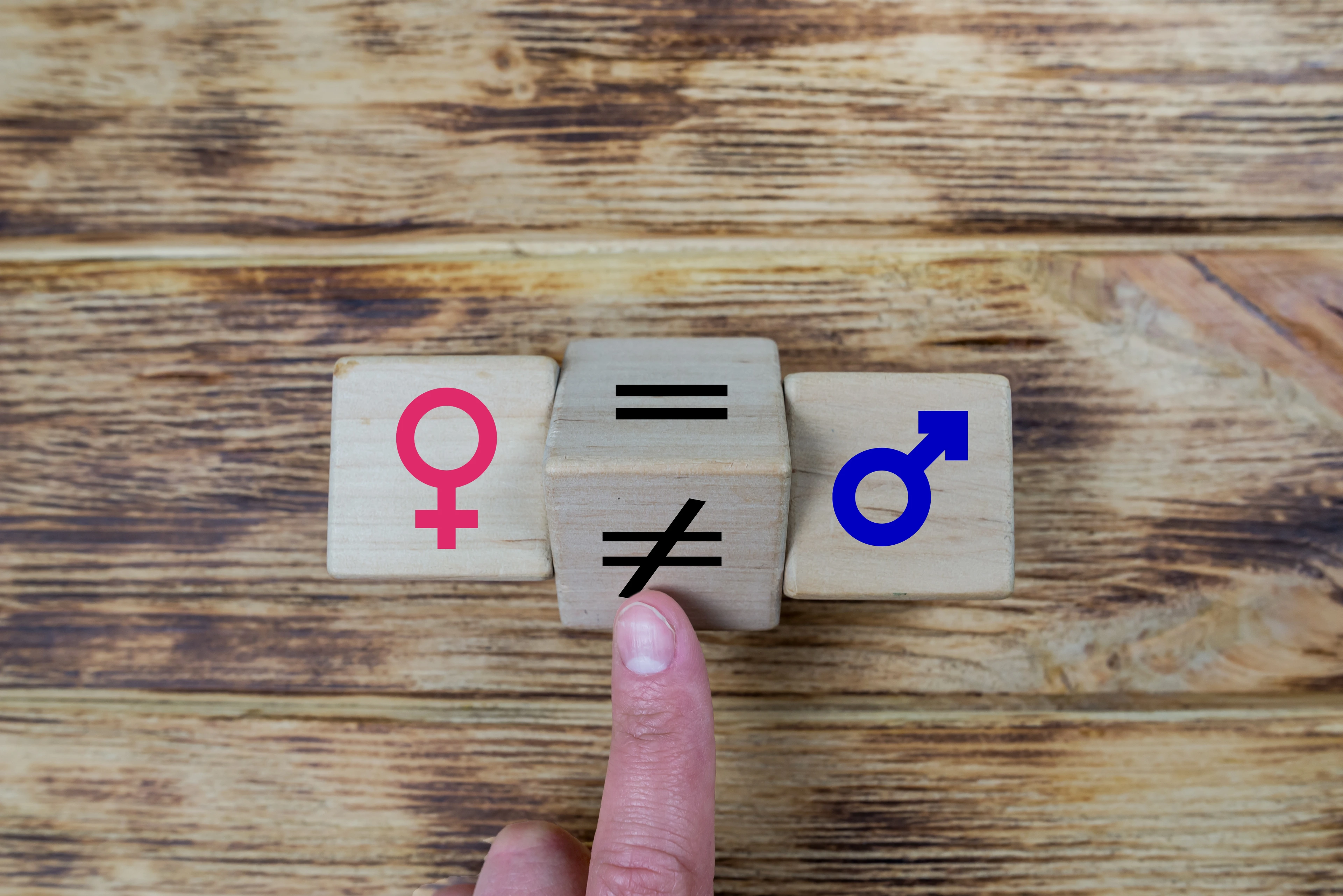 wooden cube with unequal symbol changing to equal sign