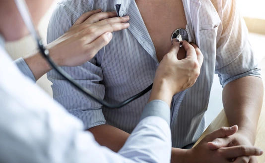 Doctor using a stethoscope checking patient