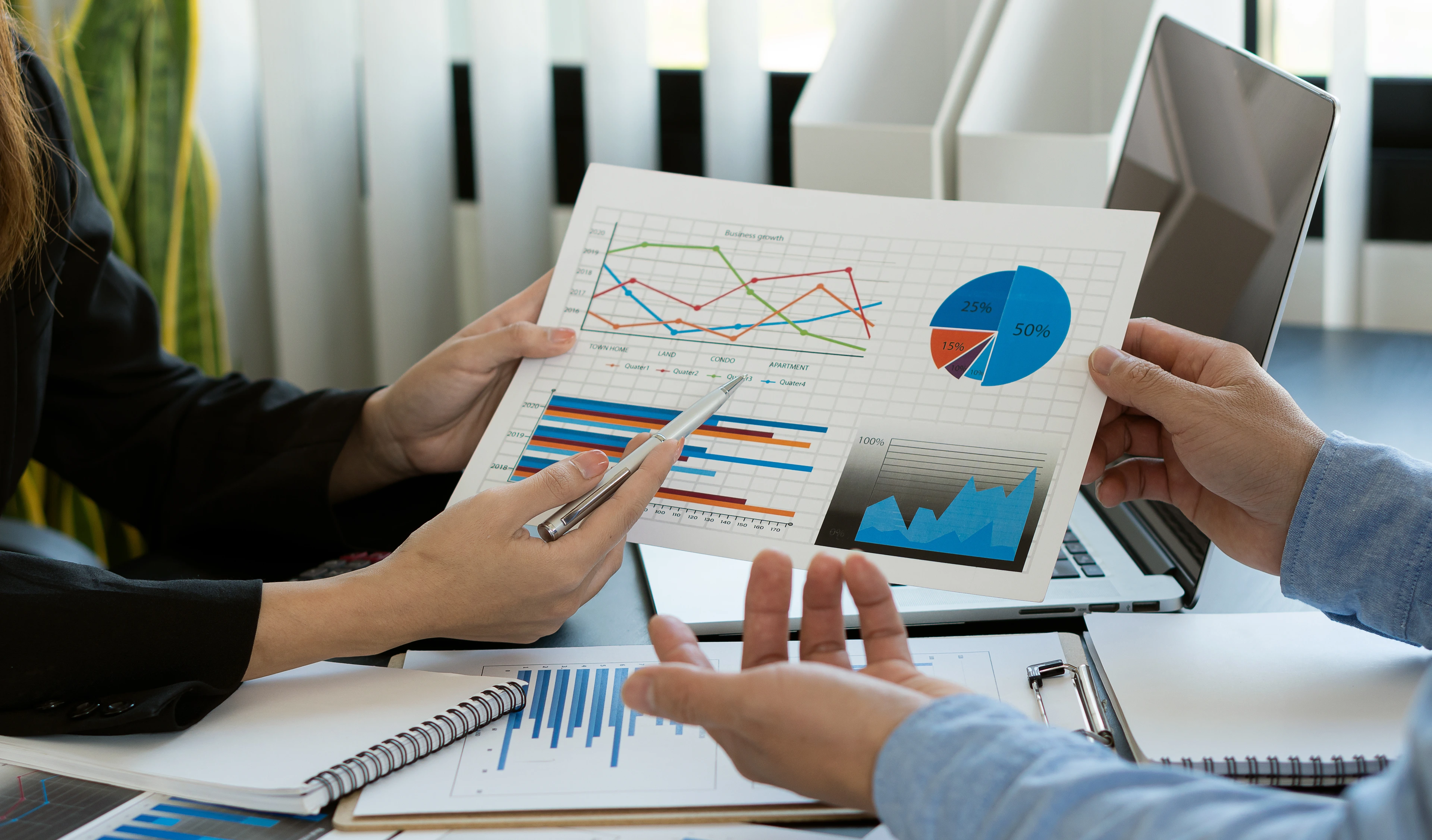 Young businessman working with laptop and graphing documents in company's multi-analysis and calculations.