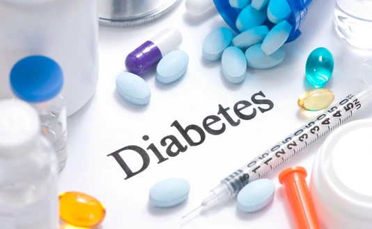 Diabetes concept with insulin, syringe, vials, pills, and stethoscope.