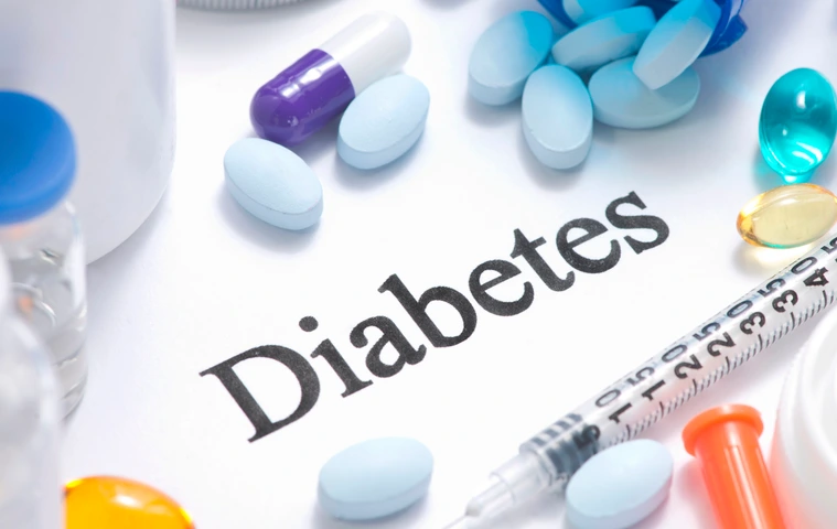 Diabetes concept with insulin, syringe, vials, pills, and stethoscope.