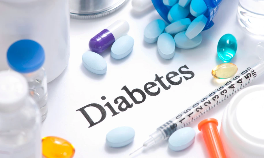 Diabetes concept with insulin, syringe, vials, pills, and stethoscope.