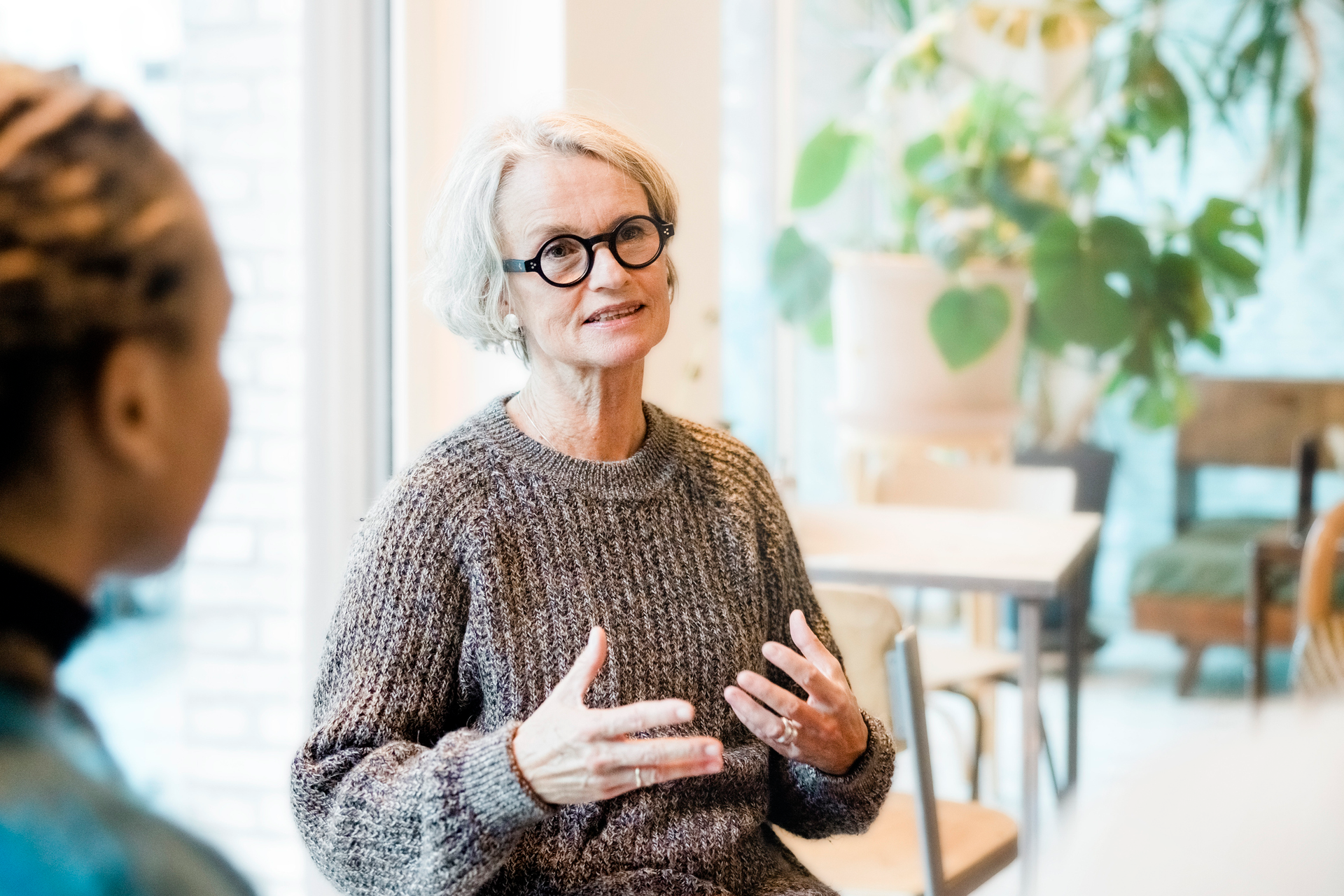 Senior woman talking with participants in a group therapy session