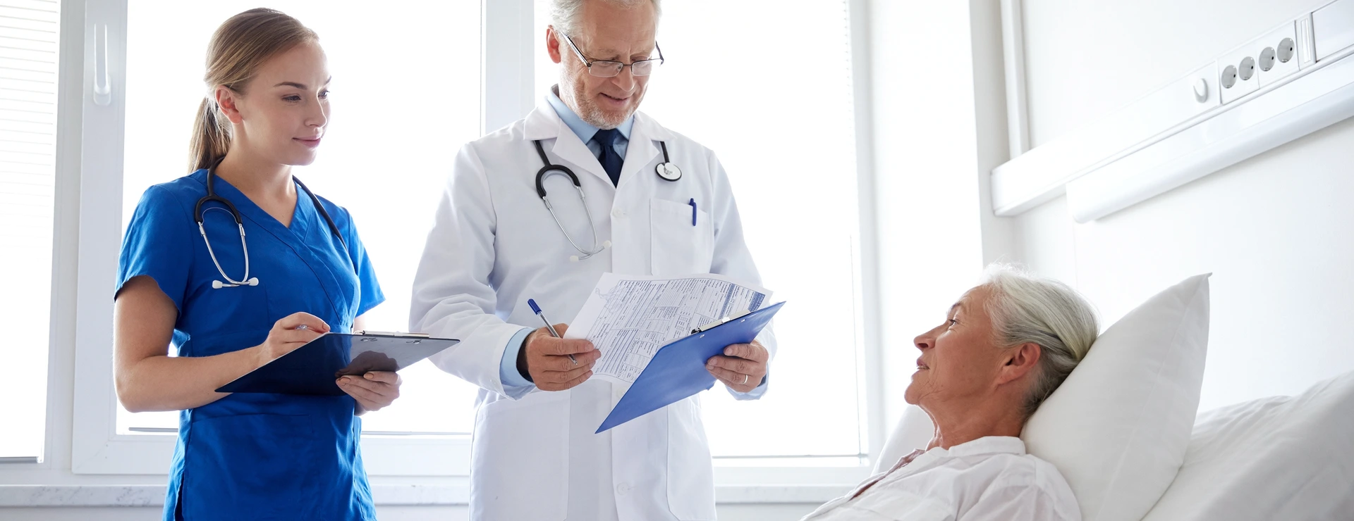 doctor and nurse visiting senior woman at hospital