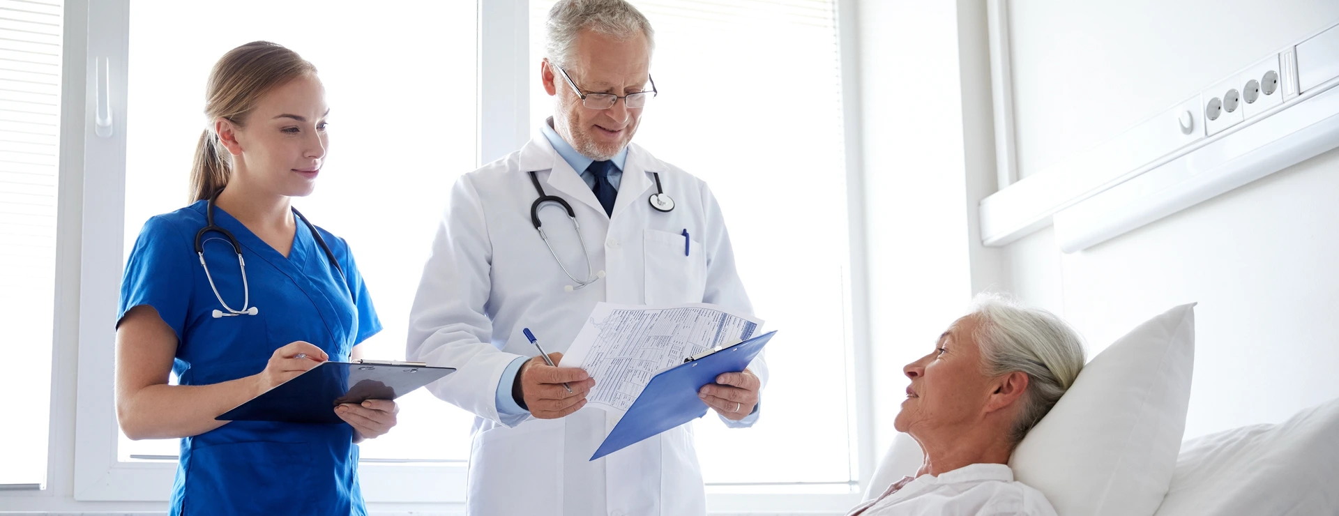 doctor and nurse visiting senior woman at hospital