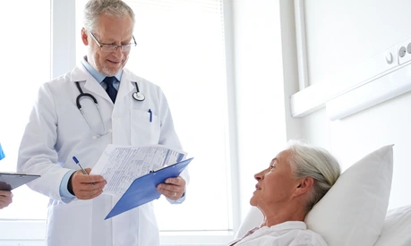doctor and nurse visiting senior woman at hospital