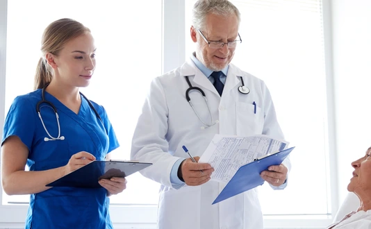 doctor and nurse visiting senior woman at hospital