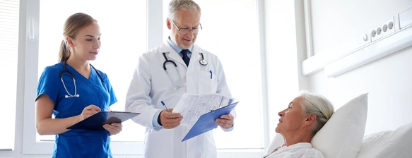 doctor and nurse visiting senior woman at hospital