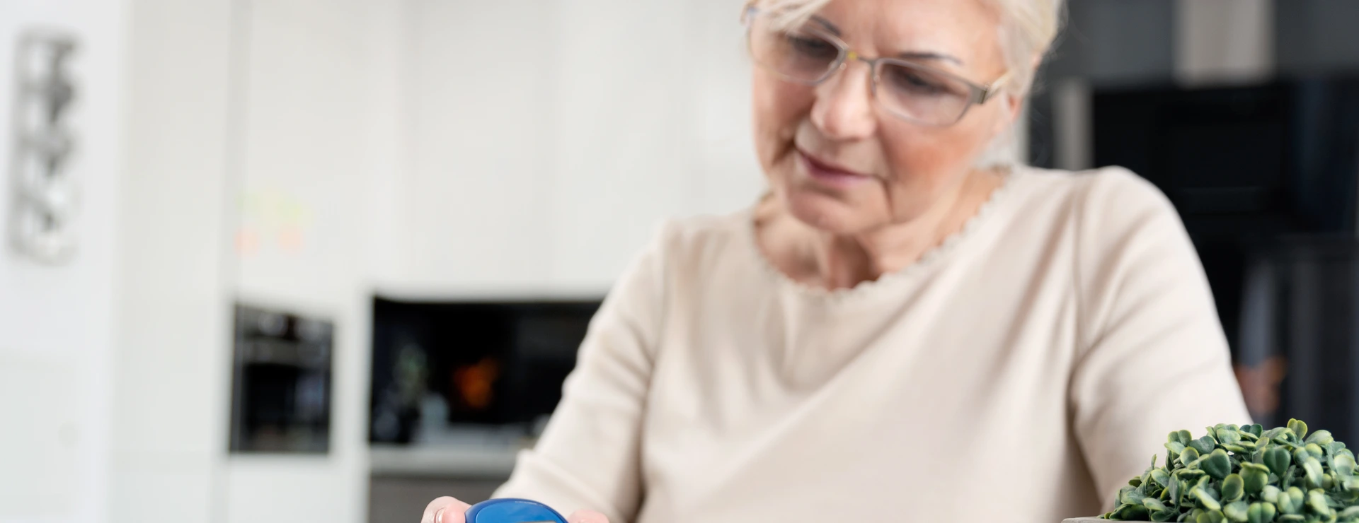 Senior woman checking blood sugar level at home