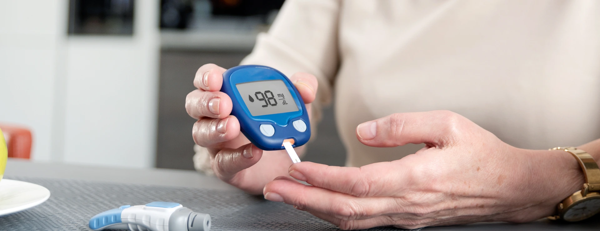 Senior woman checking blood sugar level at home