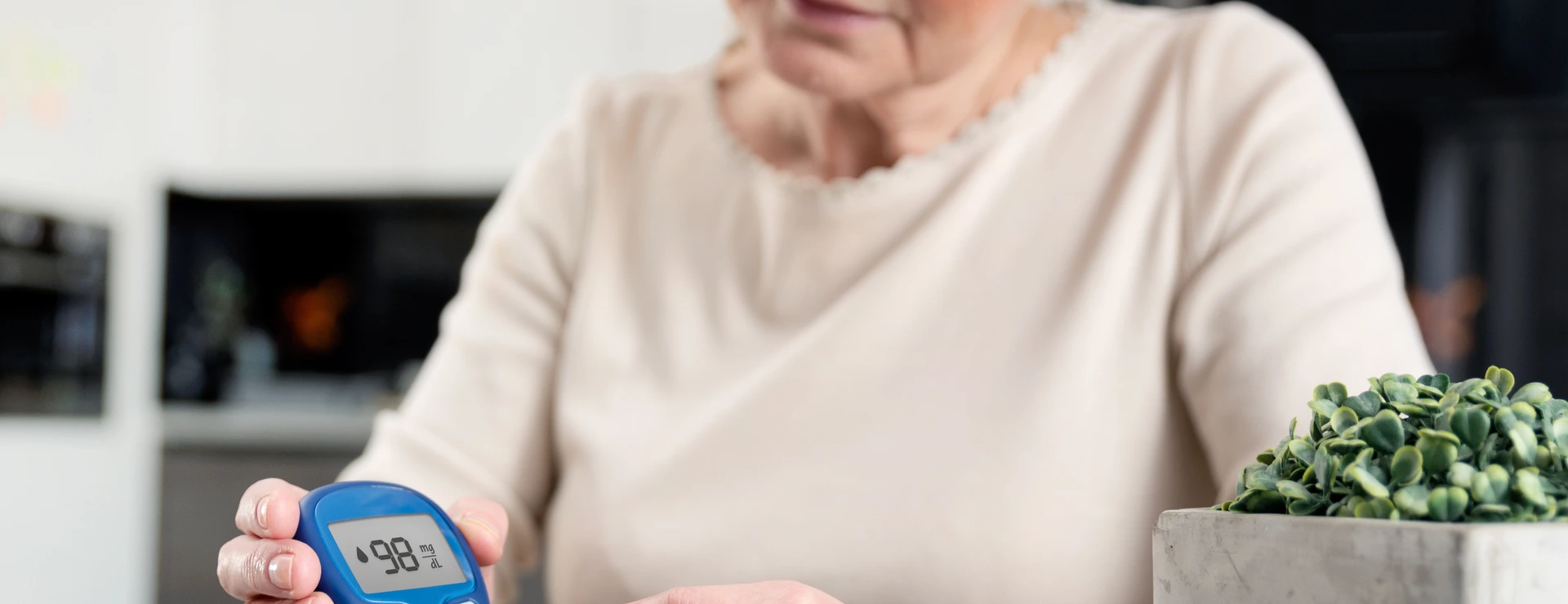 Senior woman checking blood sugar level at home