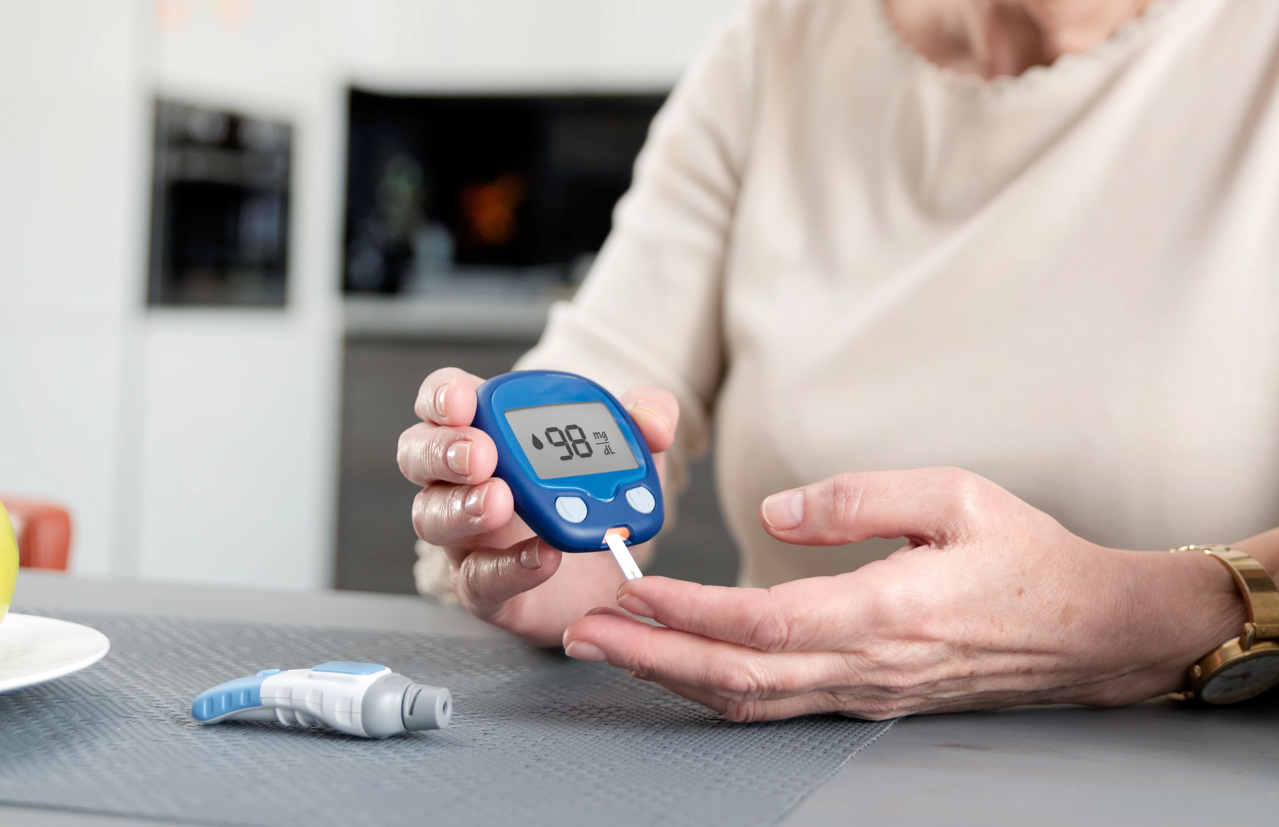 Senior woman checking blood sugar level at home