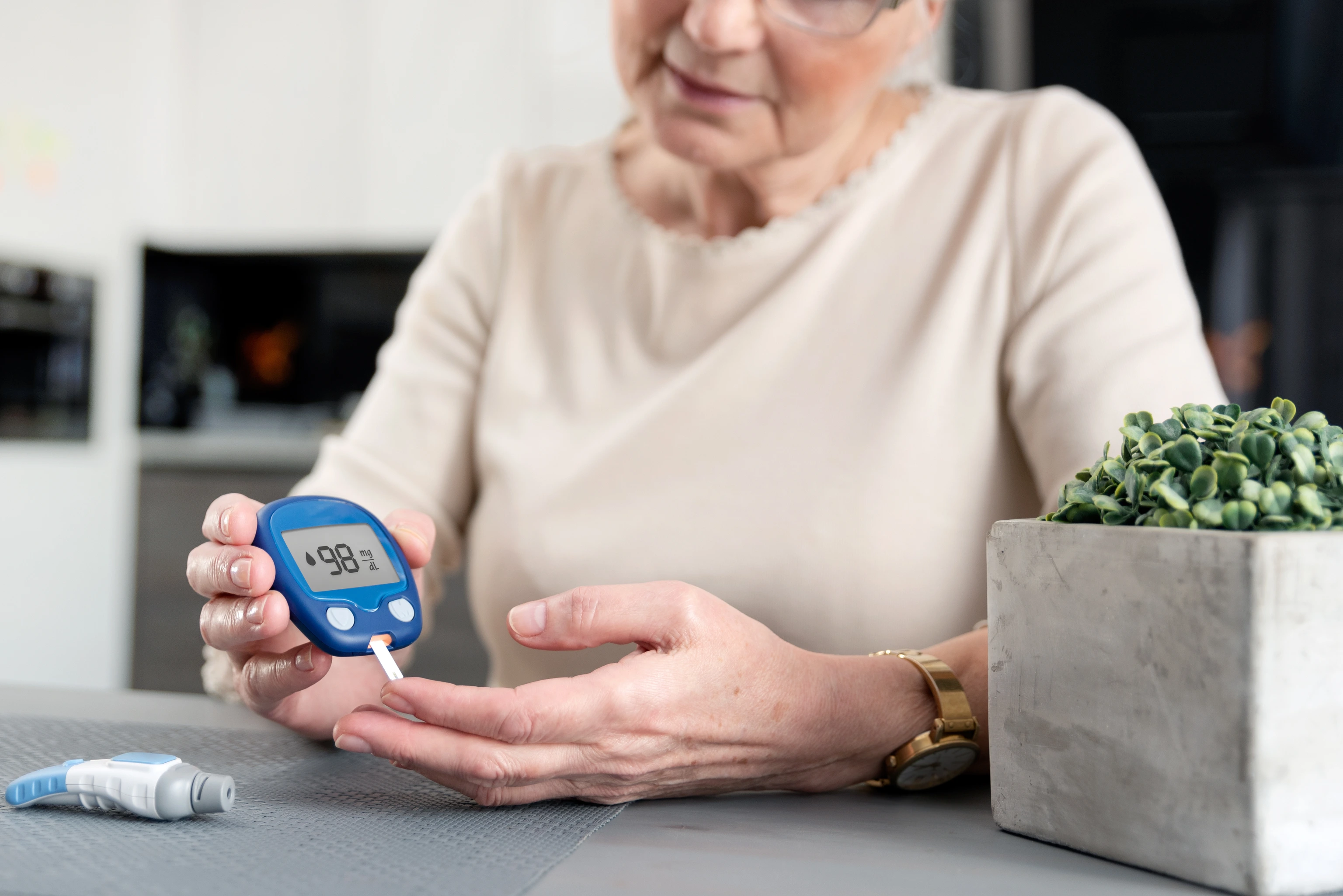 Senior woman checking blood sugar level at home