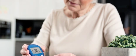 Senior woman checking blood sugar level at home