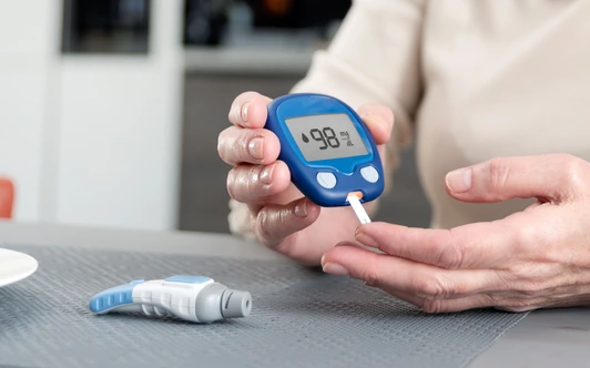 Senior woman checking blood sugar level at home