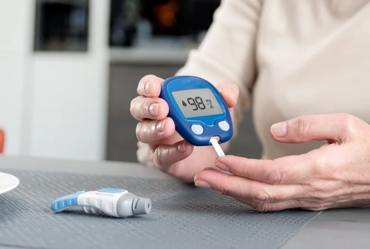 Senior woman checking blood sugar level at home