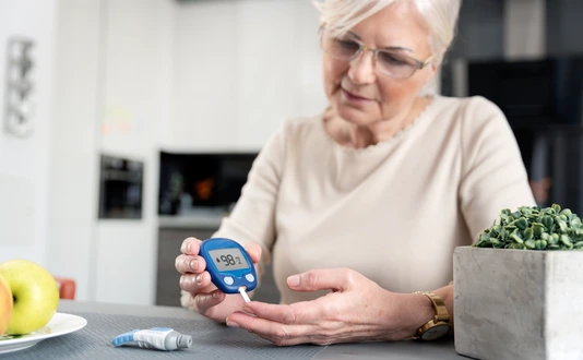 Senior woman checking blood sugar level at home