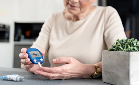 Senior woman checking blood sugar level at home