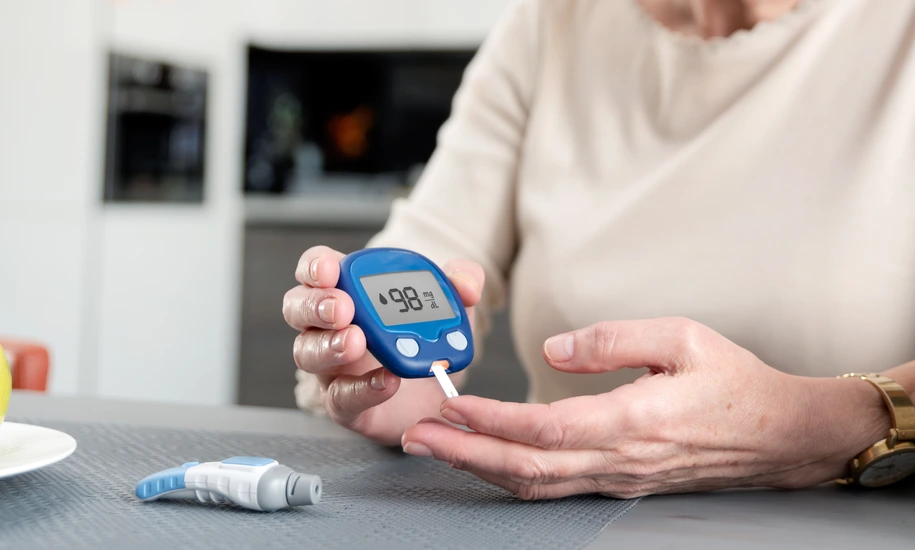 Senior woman checking blood sugar level at home