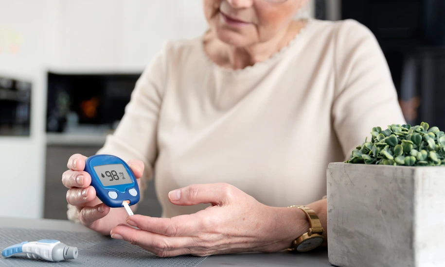 Senior woman checking blood sugar level at home