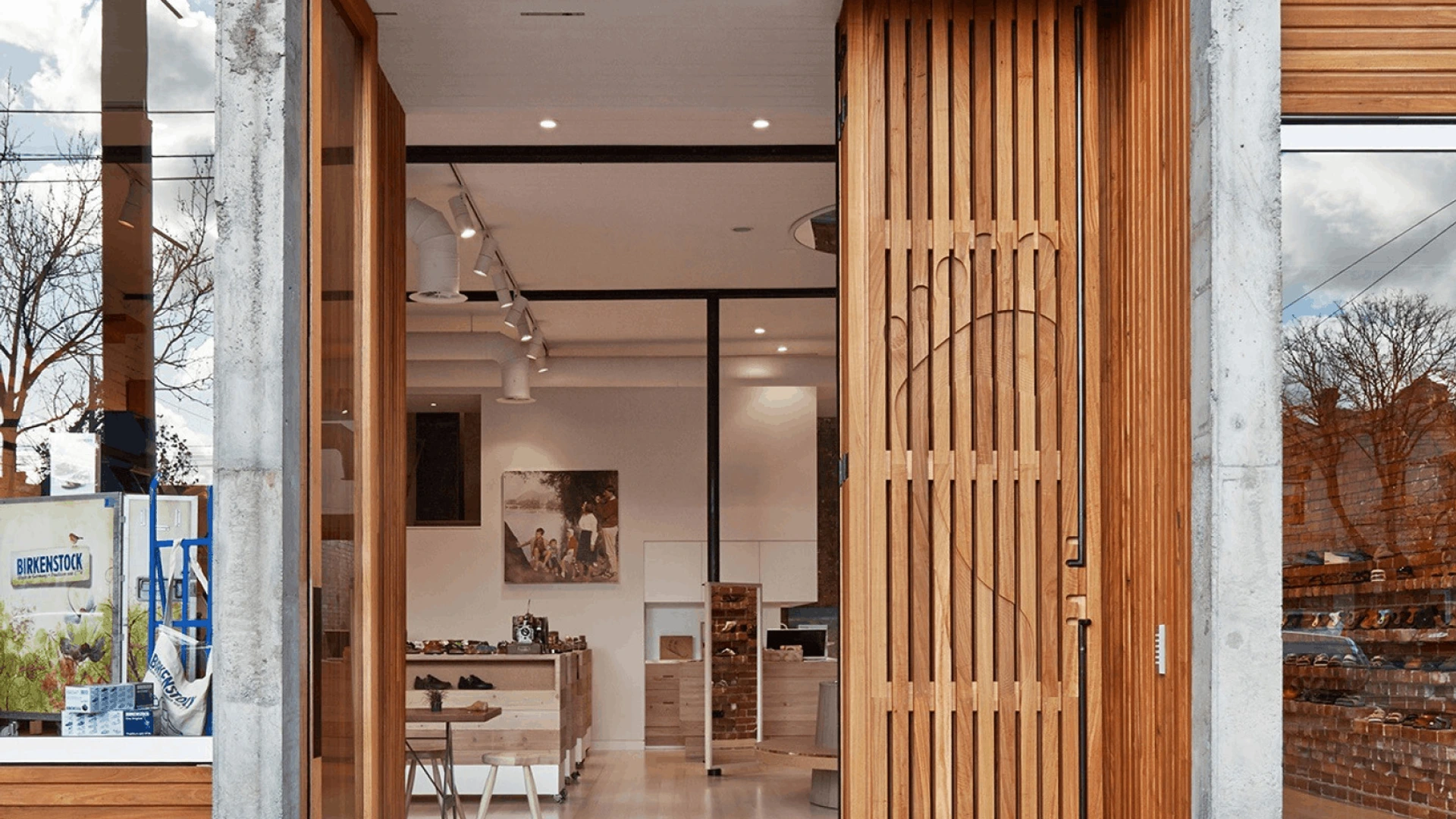 Offene Lounge mit gelben Sesseln um runden Tisch und modularer blau-grauer PALMBERG-Regalwand