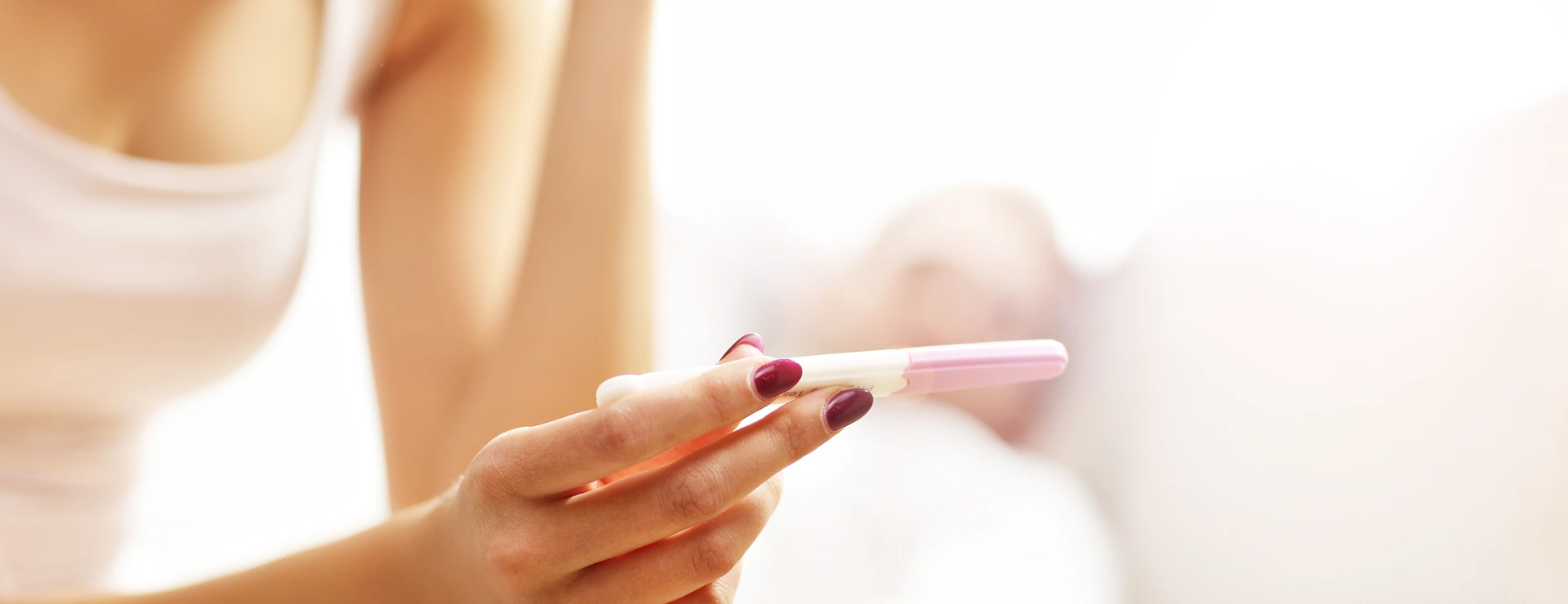 Picture showing woman with pregnancy test in bedroom