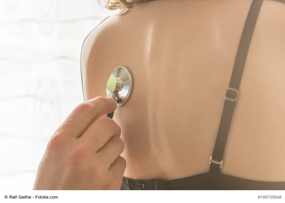 Frau wird von einem Arzt am Rcken abgehrt