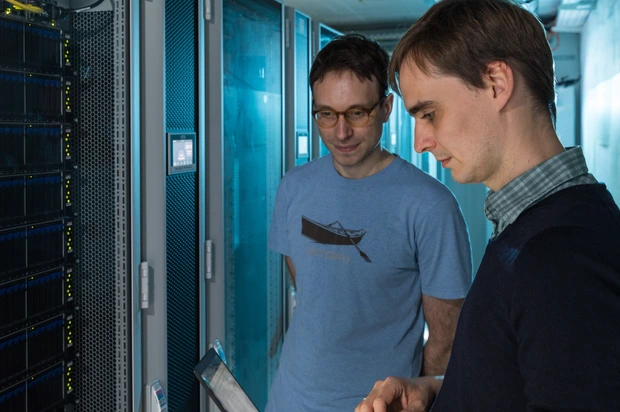 Eric Schulz (right) and Marel Binz looking at a computer