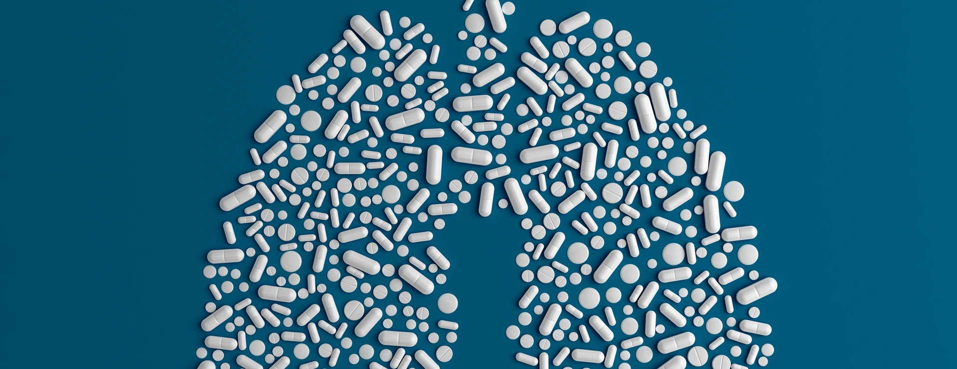 Many pills scattered on a blue uniform background in the form of a silhouette lugs man 3d illustration