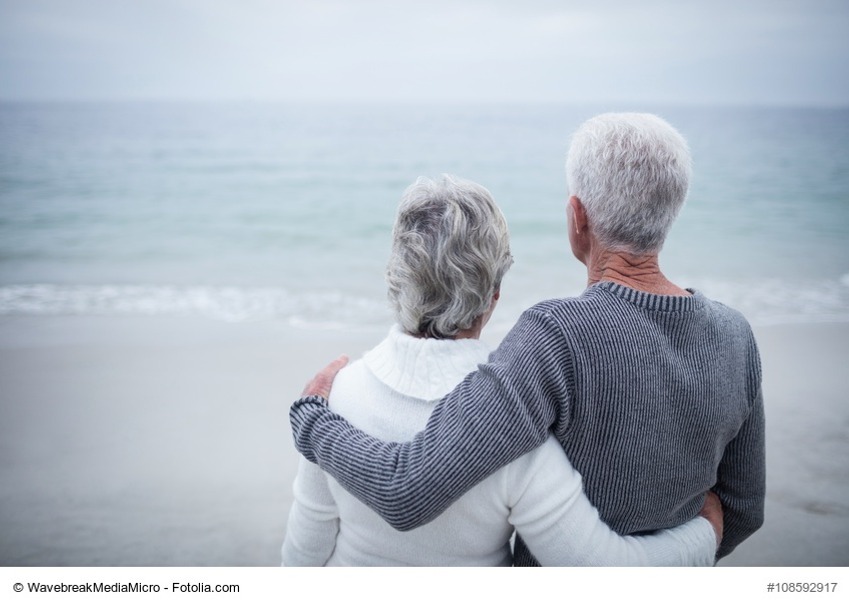 Rear view of senior couple embracing on beach