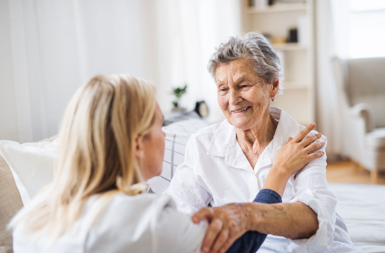 Ältere Patientin und Pflegeperson weiblich, Patienten hält Pflegende an den Armen, sie schauen sich ins Gesicht