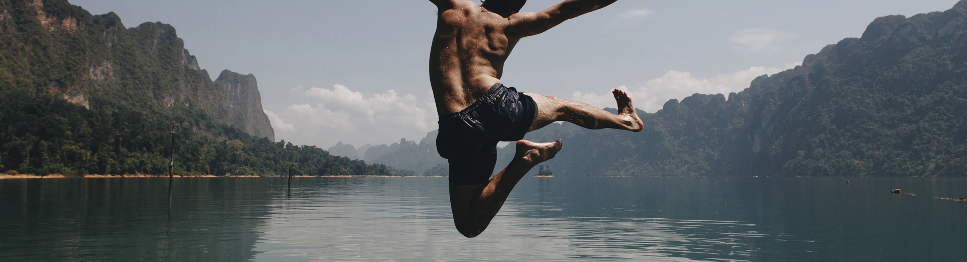 Man jumping with joy by a lake