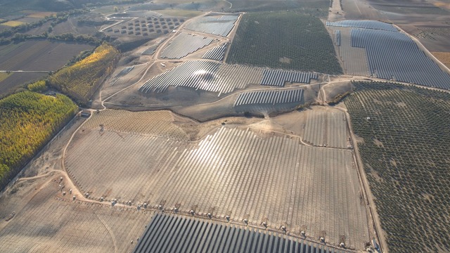 the solar farm from above with the sun reflecting off the solar panels