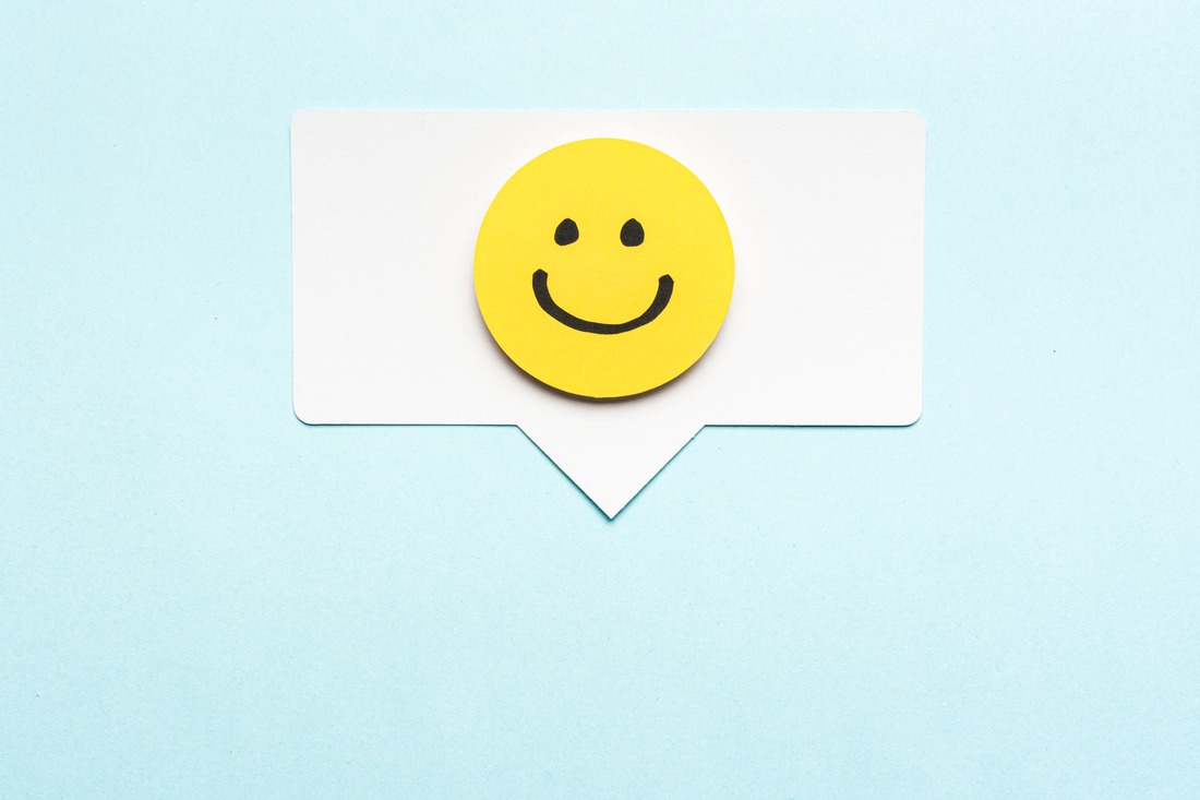 Happy face smiling comment on speech bubble and blue background.