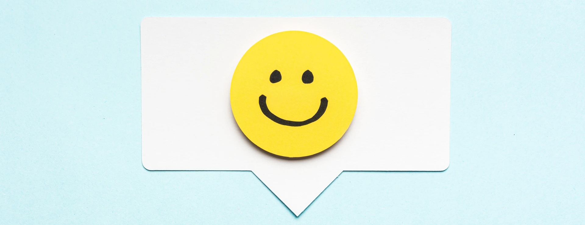 Happy face smiling comment on speech bubble and blue background.