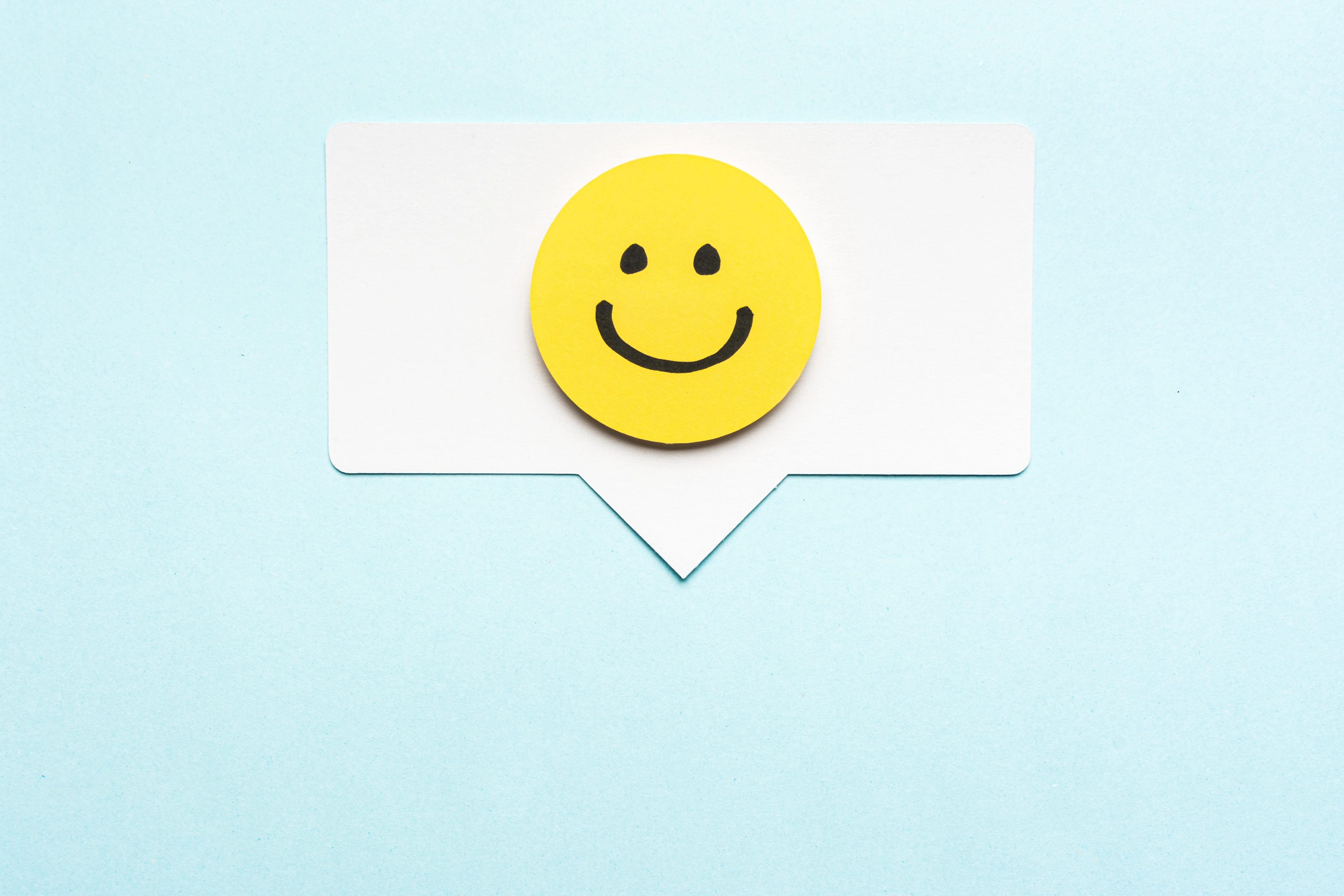 Happy face smiling comment on speech bubble and blue background.