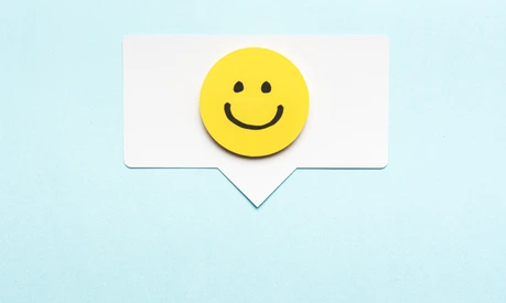 Happy face smiling comment on speech bubble and blue background.