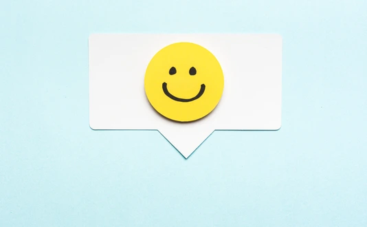 Happy face smiling comment on speech bubble and blue background.