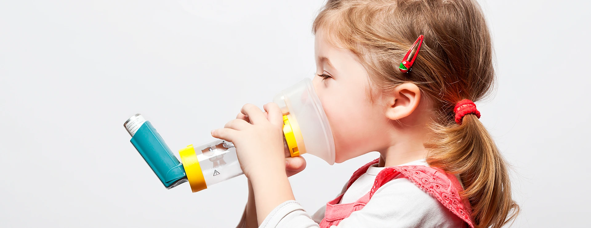 little girl doing inhlation using her inhaler
