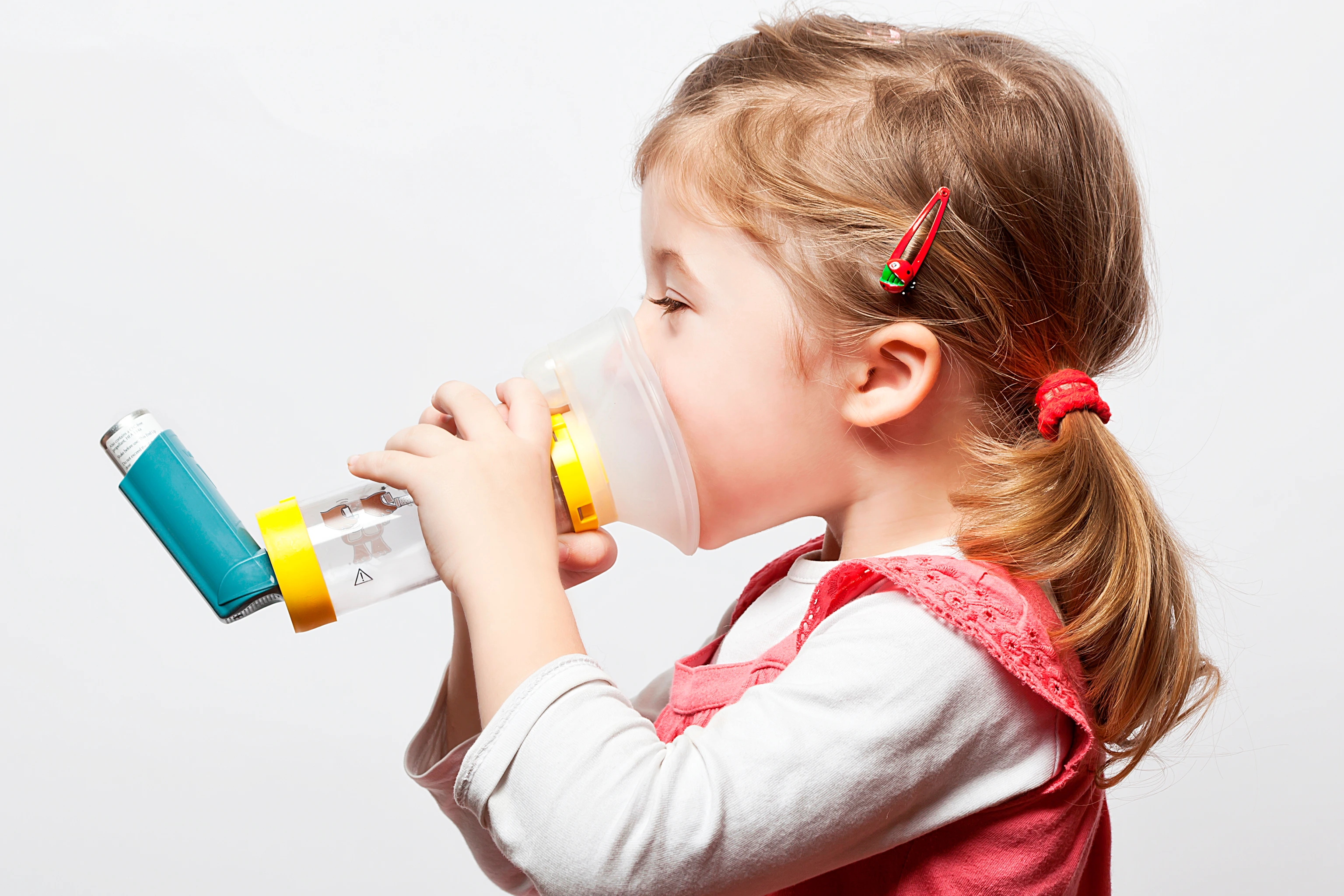 little girl doing inhlation using her inhaler