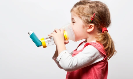 little girl doing inhlation using her inhaler