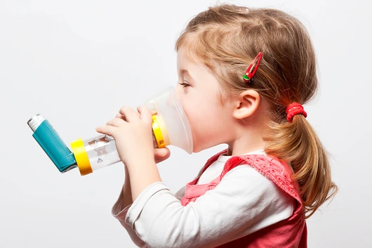 little girl doing inhlation using her inhaler