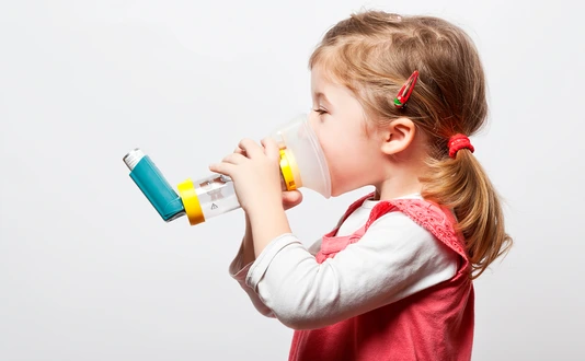 little girl doing inhlation using her inhaler