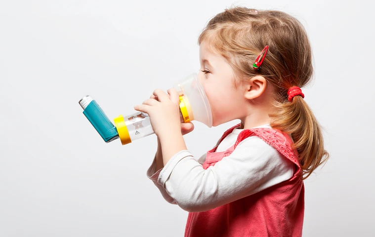 little girl doing inhlation using her inhaler
