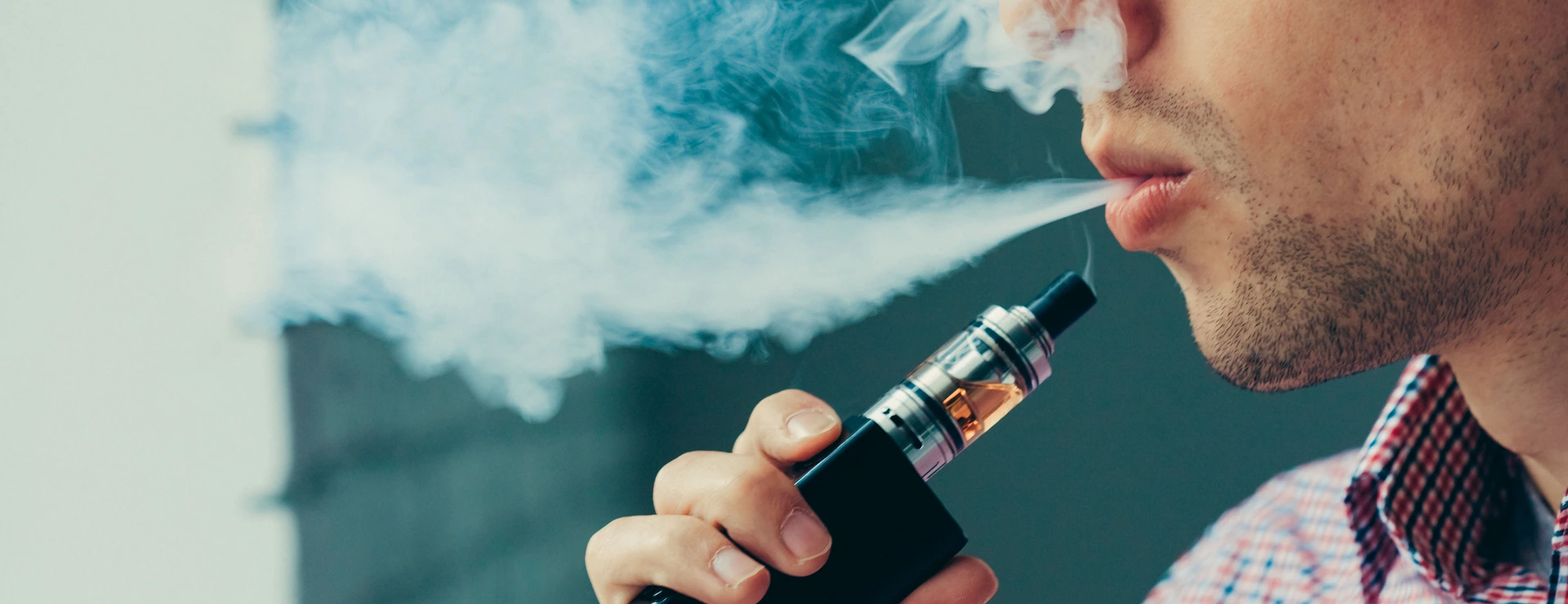 Close up on a man exhaling vapor from an electronic cigarette